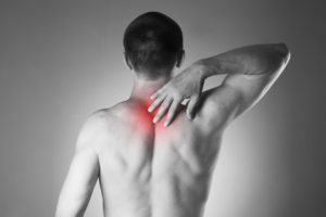 man with backache. pain in the human body. black and white photo with red dot