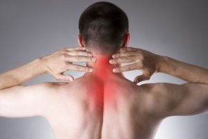 pain in the neck. man with backache. pain in the man's body on a gray background with red dot